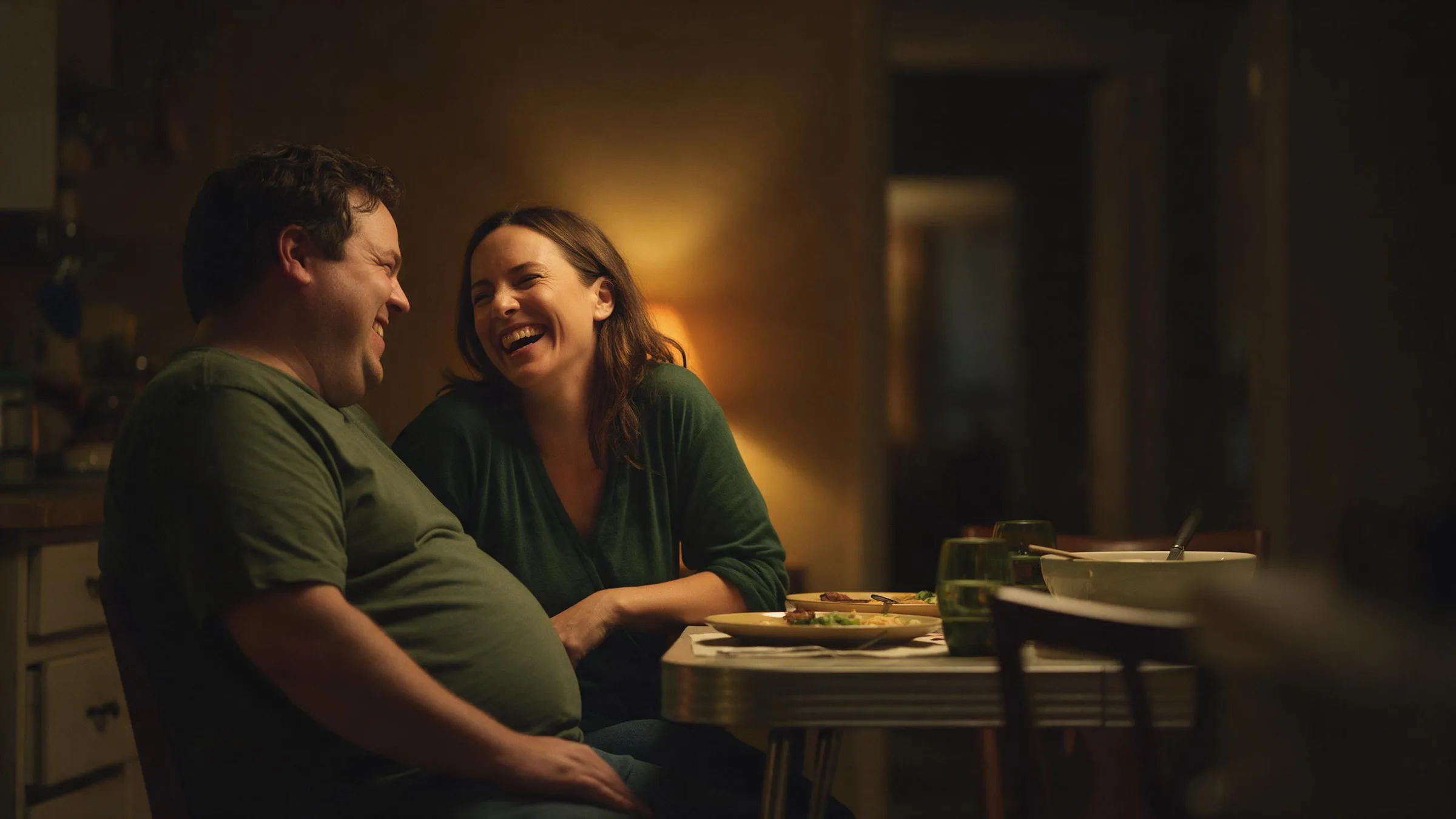 A couple laughing at the kitchen table