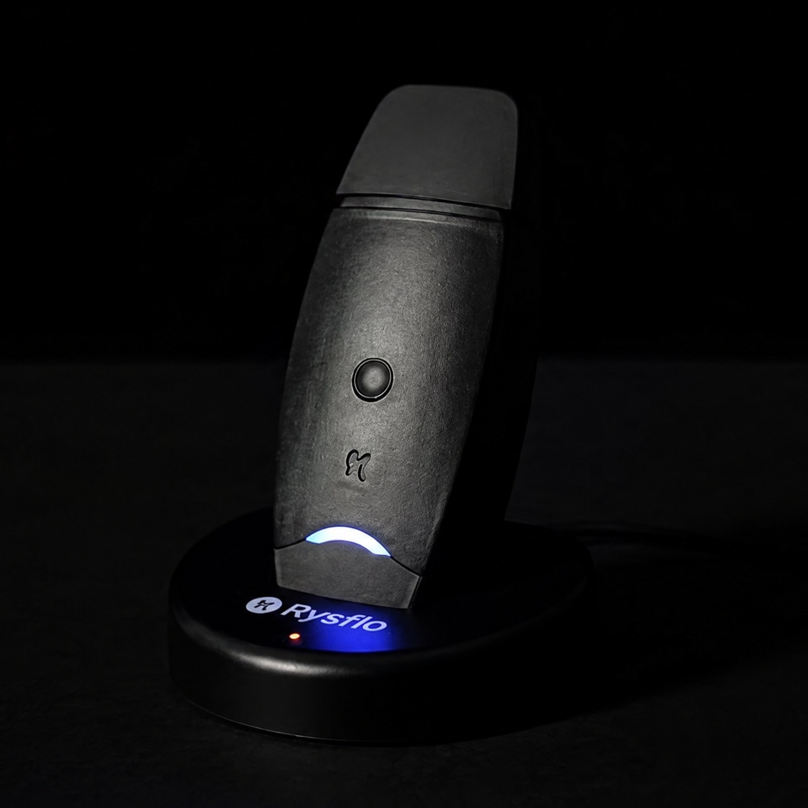 The Rysflo device on its charging dock, status light lit